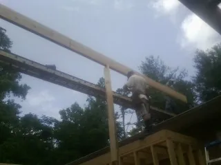 Carpenter setting a ridge beam over a new addition frame — Ice Dam Removal by Roofing Brothers in Fishkill